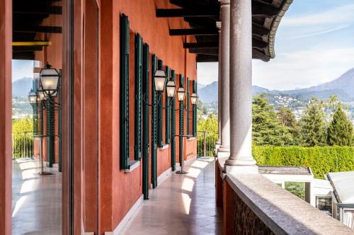 a balcony of a building with a view of the mountains at Villa Principe Leopoldo in Lugano
