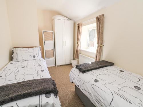 1 dormitorio con 2 camas y ventana en Blackbird Cottage en Telford