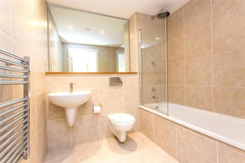 a bathroom with a sink and a toilet and a bath tub at Neptune Apartments in Leeds