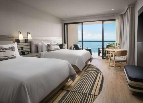 a hotel room with two beds and a view of the ocean at Alila Marea Beach Resort Encinitas, a Hyatt Resort in Encinitas