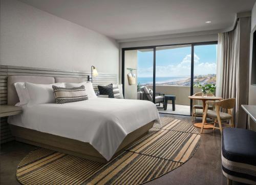 a hotel room with a large bed and a balcony at Alila Marea Beach Resort Encinitas, a Hyatt Resort in Encinitas