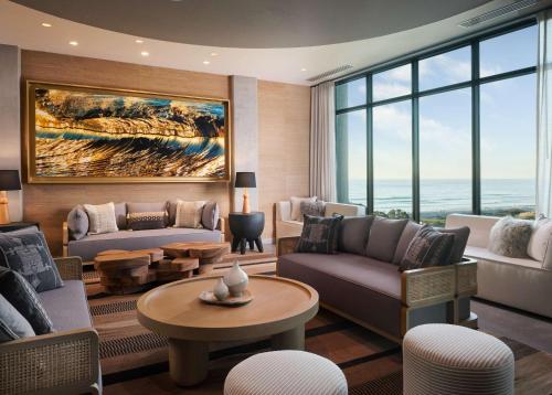 a living room filled with furniture and a large window at Alila Marea Beach Resort Encinitas, a Hyatt Resort in Encinitas