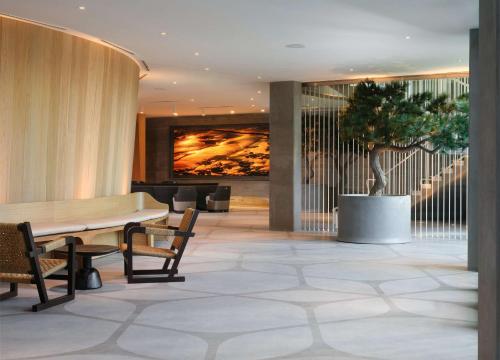 a lobby with a table and a potted tree at Alila Marea Beach Resort Encinitas, a Hyatt Resort in Encinitas