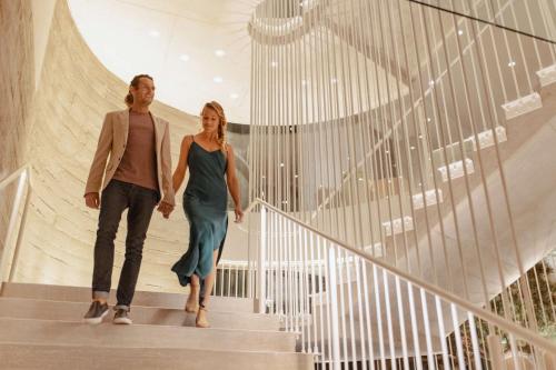 two women walking down stairs in a building at Alila Marea Beach Resort Encinitas, a Hyatt Resort in Encinitas