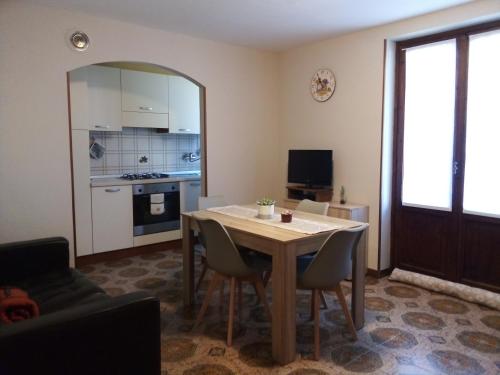 Il comprend un salon avec une table et une cuisine. dans l'établissement Appartamento Graziella, à Mollia