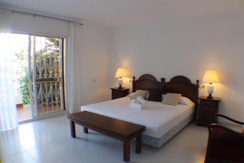 a bedroom with a bed and a table and a window at Agi Villa Cibeles in Roses