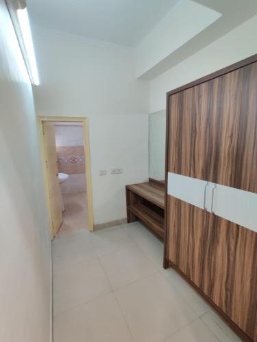 a room with a wooden cabinet and a bathroom at Raj Darbar - 10 Meter From Golden Temple in Amritsar