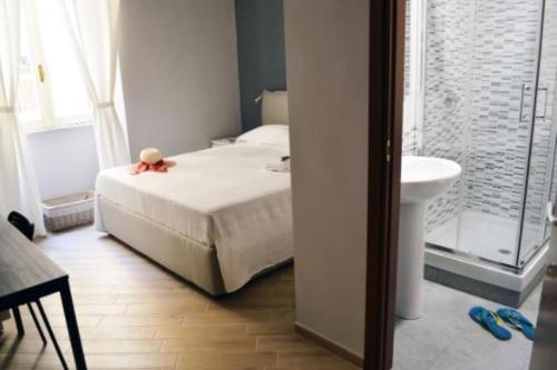 a bedroom with a bed and a bathroom with a sink at Colosshouse guest house in Rome