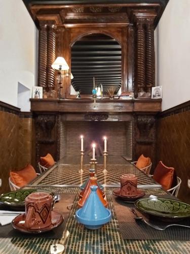 a dining room with a table with candles on it at Riad Les Nuits de Marrakech in Marrakech