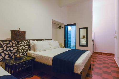 1 dormitorio con 1 cama grande y espejo en PH 19 Guesthouse Hotel in Gazcue, en Santo Domingo