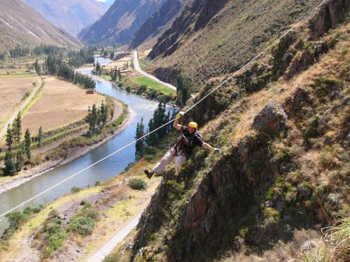 a man on a zip line over a river at Skylodge Adventure Suites in Urubamba