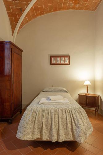 a bedroom with a bed with a dresser and a lamp at Agriturismo I Bonsi in Reggello