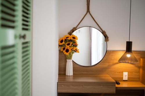 a mirror on a table with a vase of flowers at The View Hotel in Cam Lâm