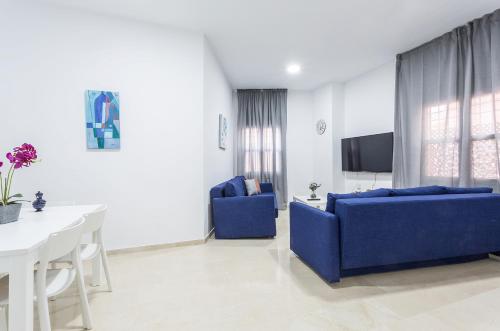 a living room with a blue couch and a white table at Centro 4 Rooms 3 baños Parking in Jerez de la Frontera