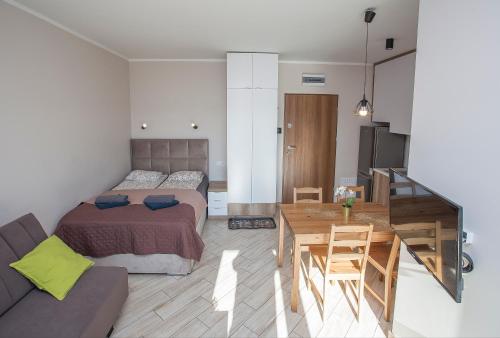 een slaapkamer met een bed, een tafel en een bank bij Urban Jungle - Sara Apartment in Białystok