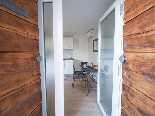 a room with a wooden wall and a dining room with a table at Bellano Holidays - Casa Ortensia in Bellano