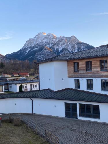 un edificio blanco con una montaña en el fondo en BERGWERK #nofilter, en Schwangau