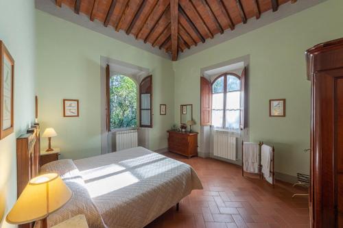 a bedroom with a large bed and two windows at Agriturismo I Bonsi in Reggello