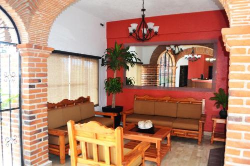 a restaurant with benches and a table and chairs at Hotel Rinconada de Cortes in Cuernavaca