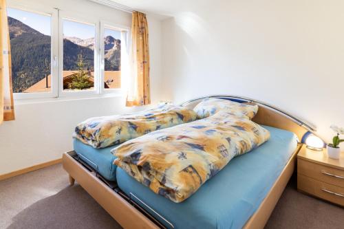 a bedroom with a bed with two pillows and a window at Chalet Hannegg 2 in Wengen