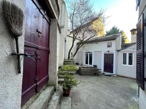 een garage met een rode deur en een huis bij L'appartement à la campagne in Vermenton