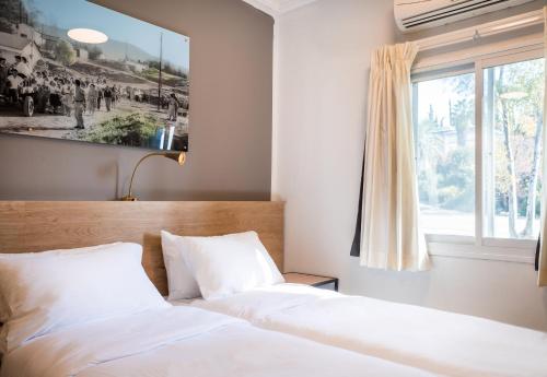 a bedroom with two white beds and a window at איילת השחר אירוח גלילי - Ayelet Hotel in Ayelet HaShahar