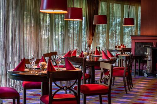 um restaurante com mesas e cadeiras com guardanapos vermelhos em Cornelia Diamond Golf Resort & Spa em Belek
