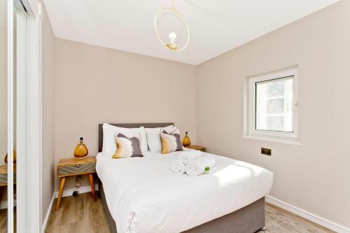 um quarto com uma grande cama branca e uma janela em Newly Reno'd 2 Bed with Free Parking em Edimburgo