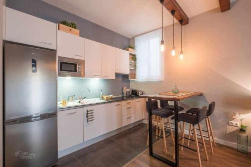 eine Küche mit einem Kühlschrank und einem Tisch mit Stühlen in der Unterkunft Parking Free - Cathedral Area Apartment in Sevilla