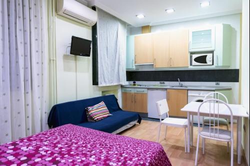 Habitación pequeña con cama morada y cocina. en Suitur Apartment Hita I Centro Madrid, en Madrid