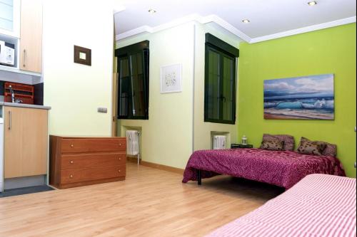 um quarto com 2 camas e paredes verdes em Suitur Apartment Hita III Centro Madrid em Madri