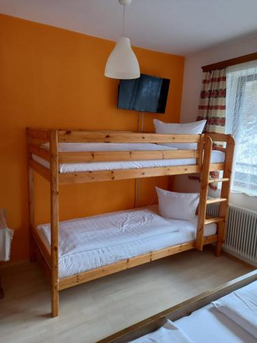 2 literas en una habitación con paredes de color naranja en Gasthof zum Pfandl, en Bad Ischl