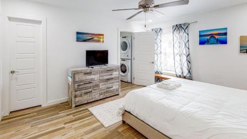 a bedroom with a bed and a flat screen tv at EC234 Newly Remodeled, One Bedroom, Second Floor Condo, Shared Pool, Grills and Boardwalk in Port Aransas