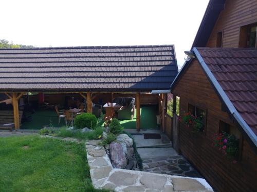a house with a black roof and a stone pathway at Ubytovanie Privat Antoni - apartmán v RD in Tvrdošín