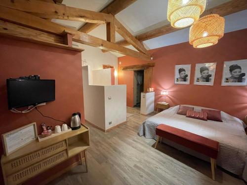 a bedroom with a bed and a flat screen tv at La Gourmandine in Saint-Andiol