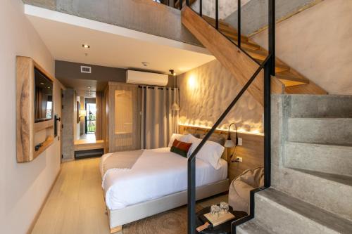 a bedroom with a white bed and a staircase at Landmark Hotel in Medellín