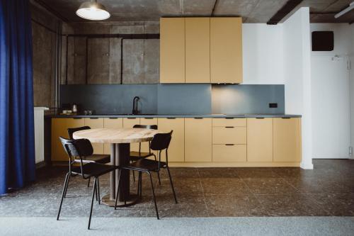 a kitchen with a wooden table and chairs at Cukrownia Żnin in Żnin