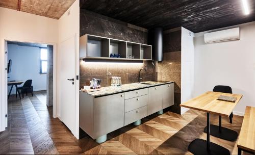 a kitchen with white cabinets and a wooden table at Cukrownia Żnin in Żnin