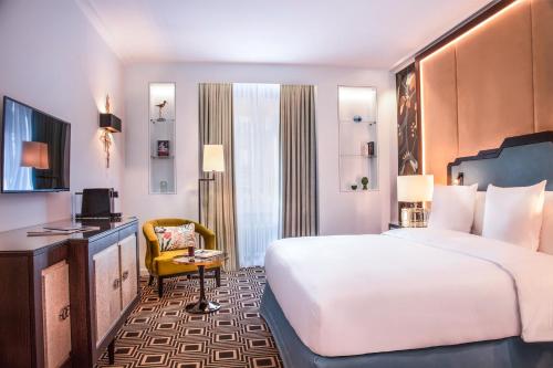 a hotel room with a bed and a desk at Hotel Bristol in Geneva