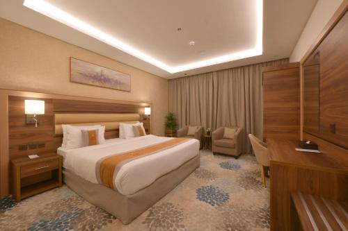 a hotel room with a large bed and a desk at Azard Hotel in Al Madinah