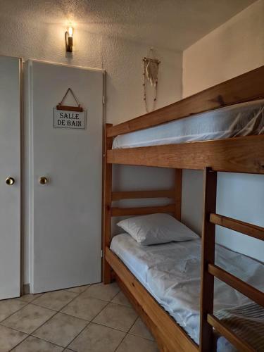 - une chambre avec 2 lits superposés et un panneau sur la porte dans l'établissement LES CAPITELLES 5 - Accès direct à la plage depuis le jardin - T2 avec cabine - 6 pers - jardin - Piscine - parking, à Saint-Cyprien