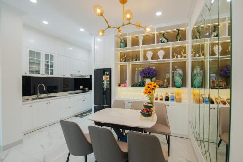 a dining room with a table and chairs and a kitchen at The View Hotel in Cam Lâm