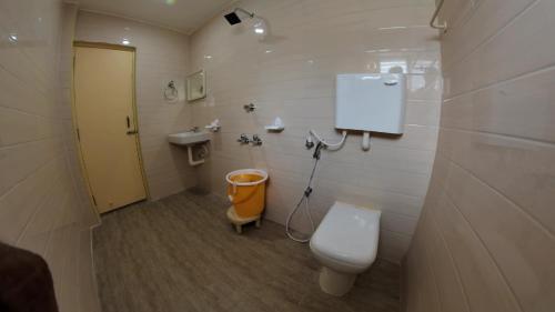 a bathroom with a toilet and a sink at Hotel Grand Stay in Tiruchchirāppalli