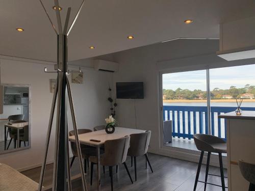 a dining room with a table and a balcony at Appartement Du Lac in Hossegor