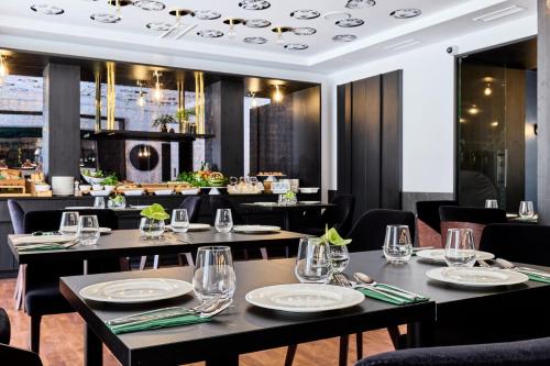 a restaurant with tables and chairs and a bar at Hotel Liberte 33 BW Premier Collection in Poznań