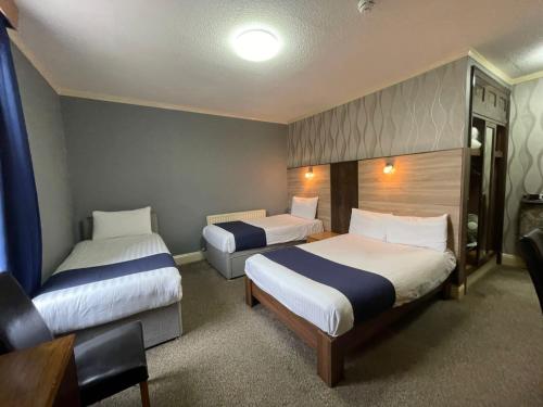 a hotel room with two beds and a desk at The Continental Hotel, Derby in Derby