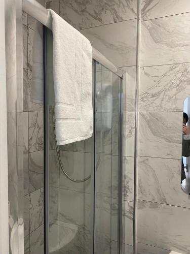 a bathroom with a shower with a towel hanging on the wall at Lady Hamilton Inn in Portsmouth