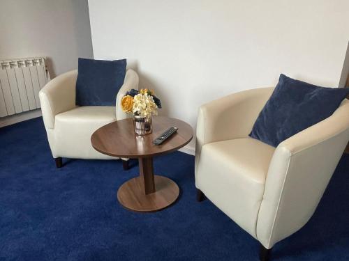 two chairs and a table with a vase of flowers at The Continental Hotel, Derby in Derby