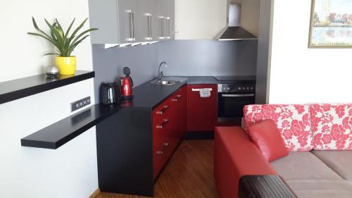 a small kitchen with a red couch in a room at Wilde Guest Apartment Tigutorn in Tartu