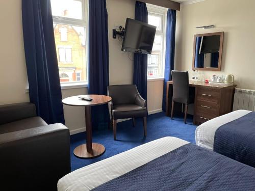 a hotel room with a bed and a table and a tv at The Continental Hotel, Derby in Derby